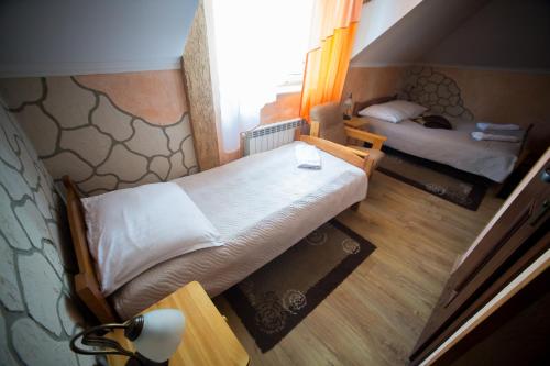 a small bedroom with two beds and a window at Hotel & Spa Arkadia in Tomaszów Lubelski