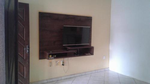 a room with a flat screen tv on a wall at Casa em Arraial d'Ajuda in Arraial d'Ajuda