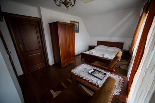 a bedroom with a bed and a table and a chair at Hotel & Spa Arkadia in Tomaszów Lubelski
