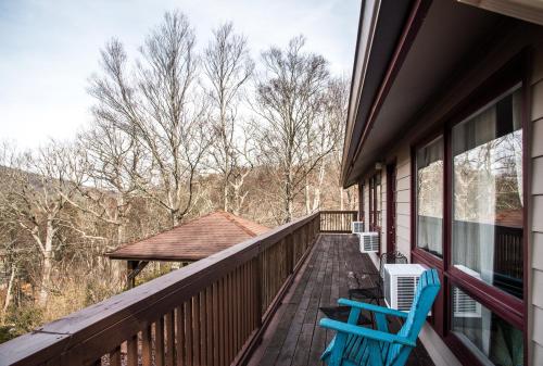 two blue chairs sitting on a porch of a house at Cliff Dwellers Inn in Blowing Rock