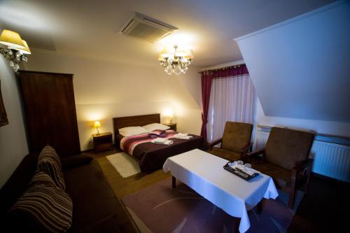 a hotel room with a bed and a table and chairs at Hotel & Spa Arkadia in Tomaszów Lubelski