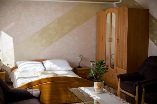 a bedroom with a bed and two chairs and a table at Hotel & Spa Arkadia in Tomaszów Lubelski