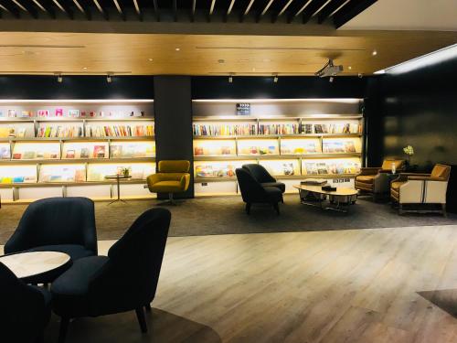 a waiting room with chairs and tables and shelves at Hub Hotel Zhongli in Zhongli