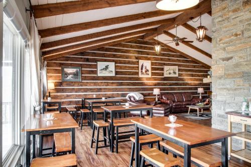 un restaurante con paredes de madera, mesas y sillas en Cliff Dwellers Inn en Blowing Rock