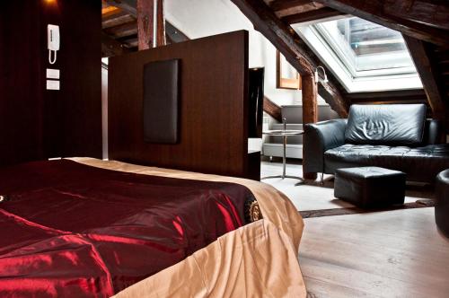 a bedroom with a bed and a couch and a chair at altana san marco in Venice