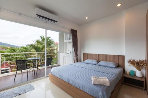 1 dormitorio con 1 cama y balcón en Number 4, en Nai Harn Beach