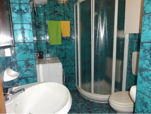 uma casa de banho com um lavatório, um chuveiro e um WC. em Bel Sole - Appartamenti em Bibione