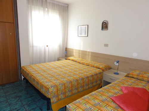 ein Hotelzimmer mit 2 Betten und einem Fenster in der Unterkunft Bel Sole - Appartamenti in Bibione