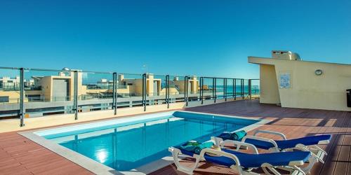 a swimming pool on the roof of a building at Birds House - Village Marina in Olhão