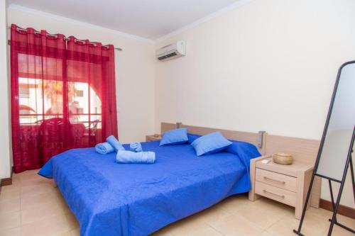 吉亞的住宿－Akisol Albufeira Guia II，一间卧室配有蓝色的床和蓝色枕头