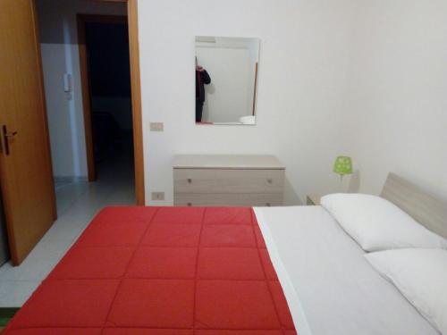 a bedroom with a white bed and a red rug at Halicia Vacanze in Salemi