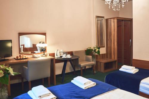 a hotel room with a desk and a mirror at Nobilton Hotel in Kraków