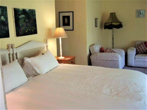 a bedroom with a large white bed and a couch at High Hopes in Greyton