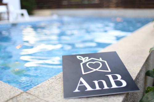 a sign in front of a swimming pool at AnB-Glass House pool villa-3BR close to Jomtien beach in Na Jomtien