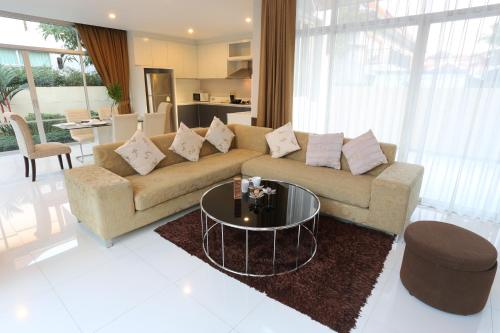 a living room with a couch and a table at AnB-Glass House pool villa-3BR close to Jomtien beach in Na Jomtien