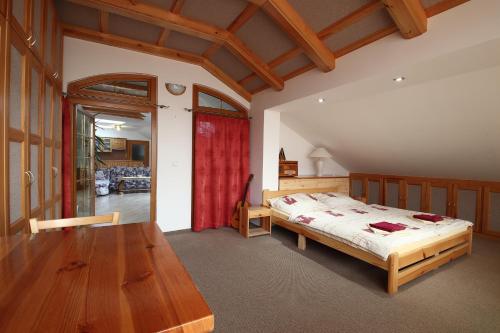 1 dormitorio con cama y mesa de madera en Penzion SURF, en Blansko