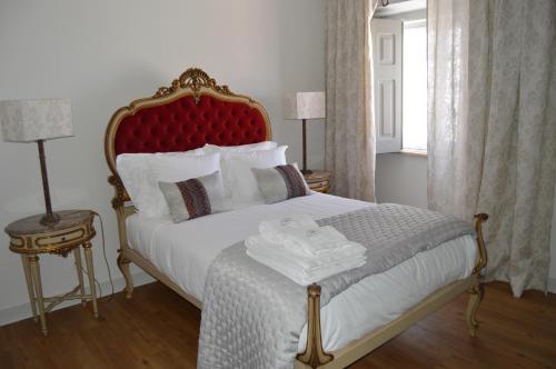 a bedroom with a large bed with a red headboard at Quinta do Piloto in Palmela