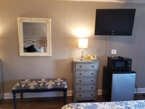 a bedroom with a dresser and a television and a bed at Gateway Inn in Chicago