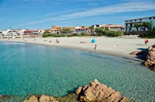 una playa con gente en la arena y el agua en A.I.R. Isola Rossa Borgo di Mare, en Isola Rossa