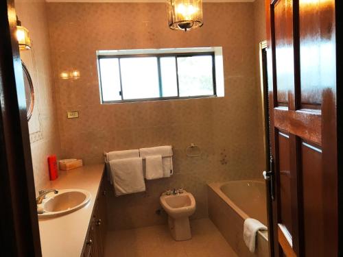 a bathroom with a sink and a tub and a toilet at Adelaide's holiday home in Modbury