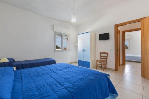 una camera con un letto blu e una sedia di Residence Tabù a Porto Cesareo