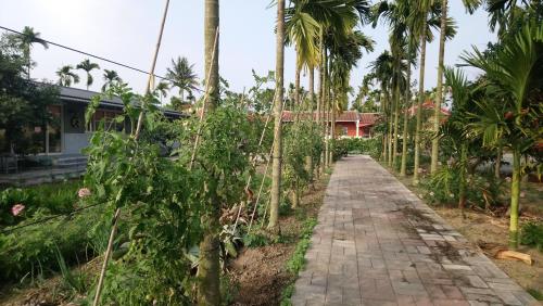 a path in front of a house with palm trees at Cishan San-Ho-Yuan in Qishan