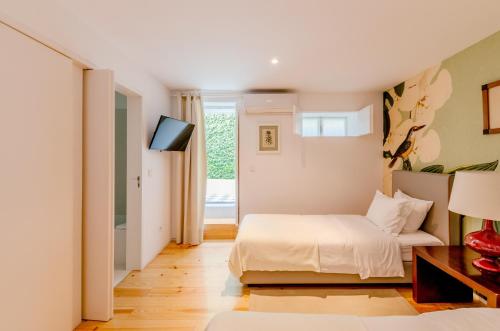 a bedroom with a bed and a television in it at Casa das Laranjas in Porto