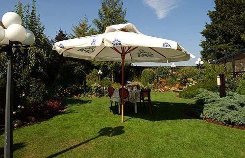 a table and chairs under an umbrella in a yard at Hostellerie Au Vieux Hetre in Jalhay