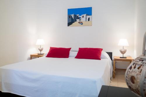 een slaapkamer met een groot wit bed met rode kussens bij Residenza La Cicala in Castro di Lecce