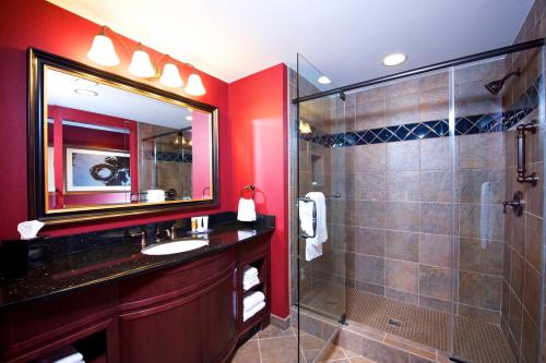 a bathroom with a shower and a sink and a mirror at Cherokee Casino West Siloam Springs Resort in West Siloam Springs