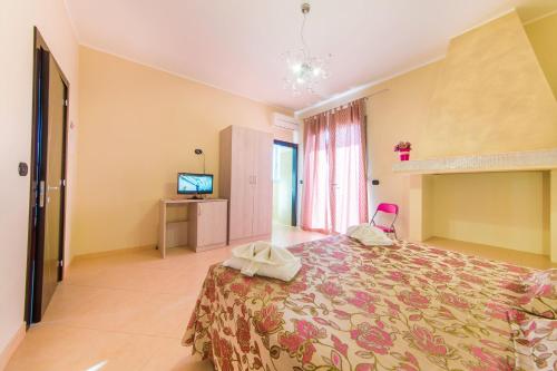 a bedroom with a bed and a television in it at B&B Rosso Salento in Alliste