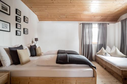 sypialnia z dużym łóżkiem i drewnianym sufitem w obiekcie Chalet Hafling Leckplått w mieście Avelengo