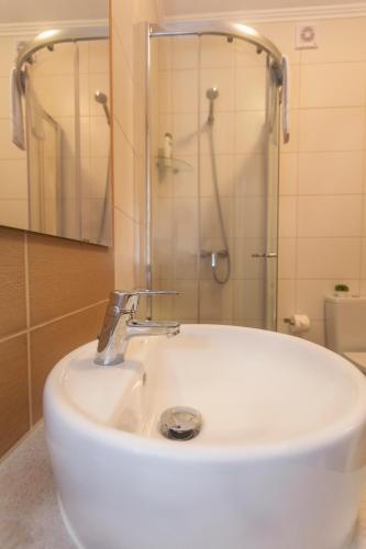 a white sink in a bathroom with a shower at Vila Barca in Madalena