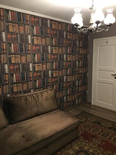 una sala de estar con sofá y una pared de libros. en Lee Apartments en Tallin