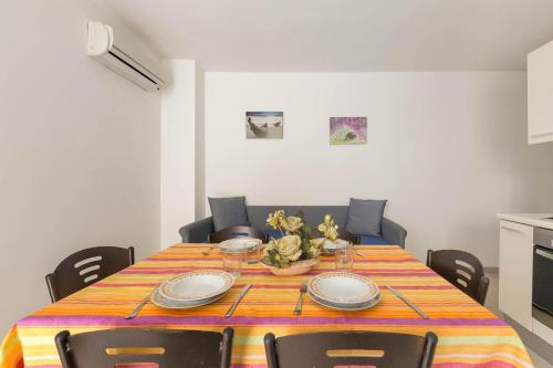 tavolo da pranzo con tovaglia e sedie colorate di Residence Tabù a Porto Cesareo