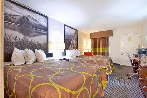 a hotel room with two beds and a desk at Super 8 by Wyndham Christiansburg in Christiansburg