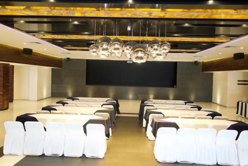 a conference room with white chairs and a projection screen at Hotel Posada Señorial in Cholula