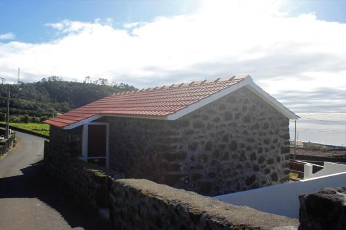 a stone house with a red roof at Melo's Place in Madalena
