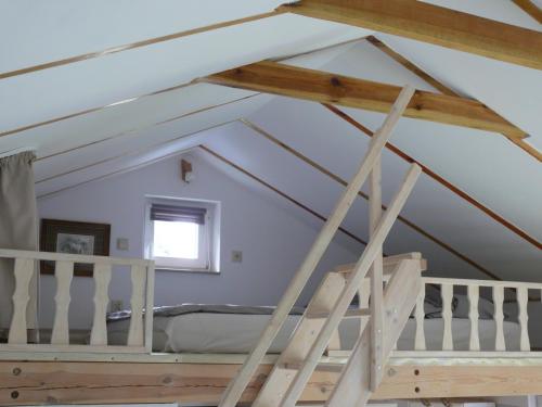 a loft conversion with a bed in a room at Domek nad jeziorem in Osieczna