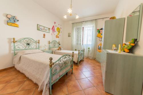 トッレ・サン・ジョヴァンニ・ウジェントにあるVilla Michelaのベッドルーム1室(ベッド2台、ドレッサー付)