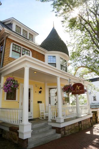 a yellow house with a white porch with a white porch at Almondy Inn Bed & Breakfast in Newport