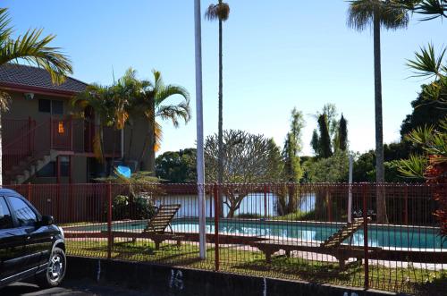 a fence with benches next to a swimming pool at Tweed River Motel in Murwillumbah