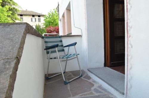 a blue chair sitting on a porch next to a door at Garni Meinrad in Ora/Auer