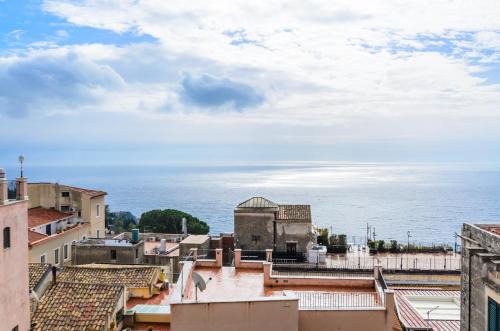 a view of the roofs of buildings and the ocean at Sweet Taormina Apartment in Taormina