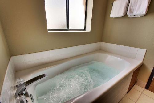 a bath tub filled with water in a bathroom at Best Western West Hills Inn in Chadron