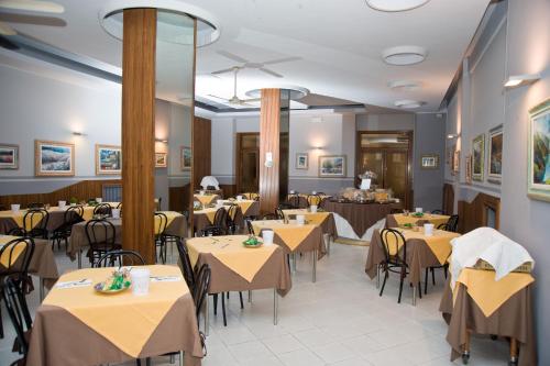 a restaurant with tables and chairs in a room at Hotel Milano in Pistoia