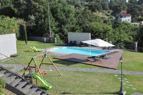a backyard with a swimming pool and a playground at Casa dos Avós by Eira dos Canastros in Espindelo