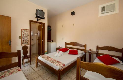 a bedroom with two beds and a tv on the wall at Pousada Pioneiro in Miranda