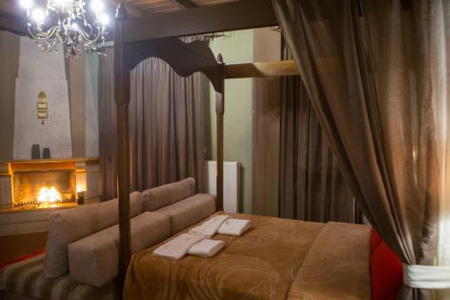 a bedroom with a canopy bed and a fireplace at Morfeas Guesthouse in Kato Loutraki
