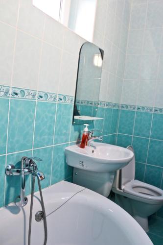 a bathroom with a sink and a toilet and a tub at Malva in Lviv